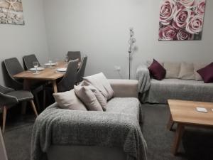 a living room with a couch and a table at Carvetii - Iona House, 2nd floor apartment sleeps up to 6 in Kirkcaldy