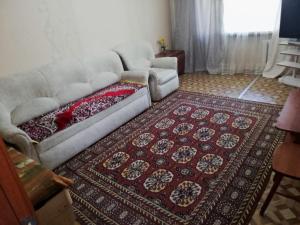 a living room with a couch and a rug at Однокомнатная Встреча in Astana
