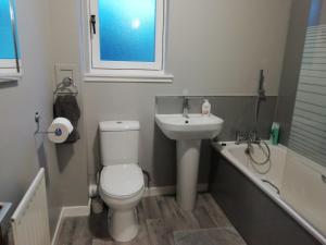 a bathroom with a toilet and a sink and a bath tub at Carvetii - Iona House, 2nd floor apartment sleeps up to 6 in Kirkcaldy