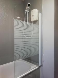 a shower in a bathroom with a glass door at Carvetii - Iona House, 2nd floor apartment sleeps up to 6 in Kirkcaldy
