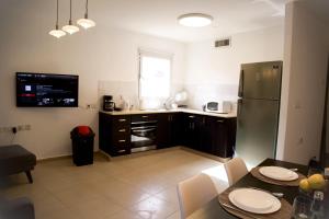 a small kitchen with a table and a refrigerator at Beautiful Apartment - Ben Yehuda - City Center in Jerusalem