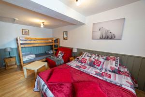 a bedroom with a bed with a red bedspread at Hotel La Source in La Foux