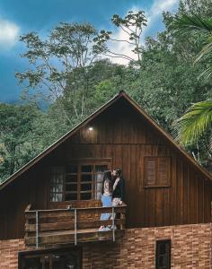 ein Paar steht auf einem Balkon eines Hauses in der Unterkunft Chalé da Pedrinha in Volta Grande