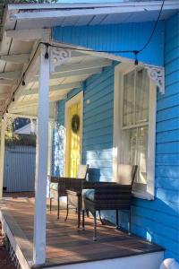 a porch with chairs and a table on a blue house at The Mellow Yellow in Sanford