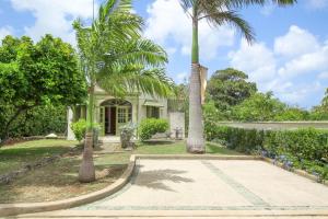 une maison avec des palmiers dans la cour dans l'établissement Marsh Mellow South Cottage by Bluescape, à Saint James