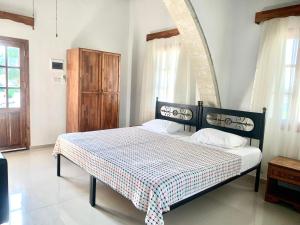 a bedroom with a bed with a checkeredkered blanket at Karpaz Lembusa Guest House in Rizokarpaso