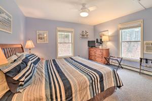 a bedroom with a bed and a dresser and windows at Portage Lake Condo with Deck and Pool Access! in Onekama