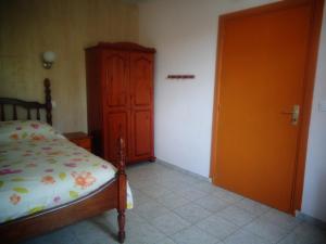 a bedroom with a bed and a wooden cabinet at Residence Madelia in Port-Louis