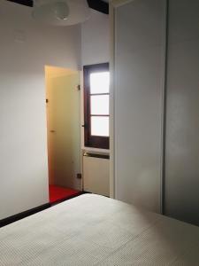 - une chambre avec un lit blanc et une fenêtre dans l'établissement El Ventanillo, à Tolède