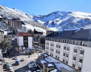 an aerial view of a city with snow covered mountains at TODOSIERRANEVADA ZONA BAJA - MONTBLANC VISTAS A LA MONTANA - Junto a los Telecabinas in Sierra Nevada