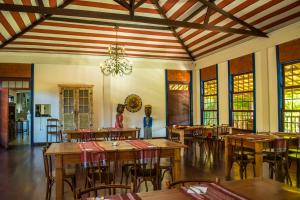 a dining room with tables and chairs and a chandelier at Pousada Candonga da Serra in Tiradentes