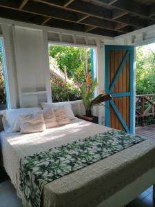 ein Schlafzimmer mit einem Bett in einem Zimmer mit einem Fenster in der Unterkunft Mi Hermosa - Casa Isleña a 70 Metros de la Playa in Providencia