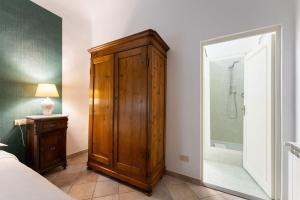 a bedroom with a wooden cabinet next to a shower at Terme Apartment in Florence +18 photos