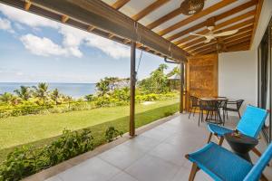 une terrasse avec une table et des chaises et l'océan dans l'établissement Paradise Chalets Yoga & Wellness, à Takamaka