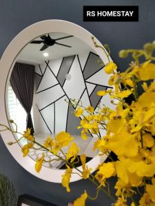 a mirror with yellow flowers in front of it at RS Homestay in Sungai Petani