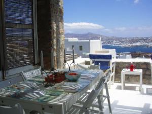 a table and chairs on a balcony with a view of the ocean at Seafarer's Appartment in Mikonos