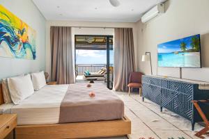 a bedroom with a bed and a view of the ocean at Paradise Chalets Yoga & Wellness in Takamaka