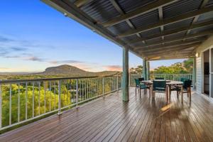 a patio with a table and chairs on a deck at Breathtaking Panoramic Ocean Views in Yaroomba