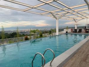 a large swimming pool with a pergola at Primavera City Brand New Condo Uptown Cagayan de Oro with pool and gym One minute walk from Mall in Cagayan de Oro