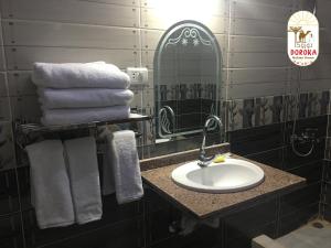 een badkamer met een wastafel, een spiegel en handdoeken bij DoroKa Nubian House in Shellal