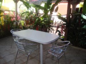 una mesa blanca y 2 sillas en el patio en Residence Madelia, en Port-Louis