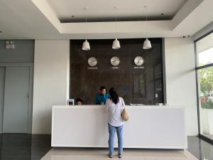 a woman standing at a counter in a restaurant at Primavera City Brand New Condo Uptown Cagayan de Oro with pool and gym One minute walk from Mall in Cagayan de Oro +17 photos