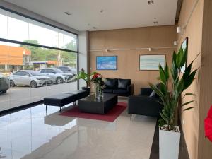 a living room with black furniture and a large window at Primavera City Brand New Condo Uptown Cagayan de Oro with pool and gym One minute walk from Mall in Cagayan de Oro