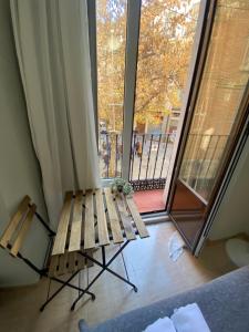 un banco de madera sentado frente a una ventana en Center Madrid habitaciones en Madrid