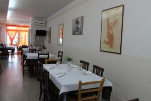 un comedor con mesas y sillas y una foto en la pared en Locanda Fosca Umbra, en Narni