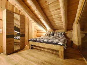 eine Blockhütte mit einem Bett in einem Zimmer in der Unterkunft Falkenblick in Hochrindl
