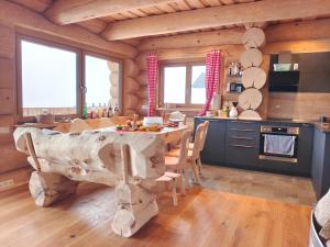 eine Küche und ein Esszimmer mit einem Tisch in einer Blockhütte in der Unterkunft Falkenblick in Hochrindl
