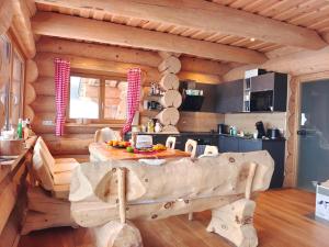 a log cabin kitchen with a large wooden bench in a room at Falkenblick in Hochrindl