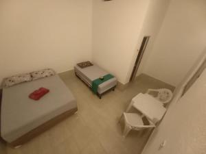z widokiem na sypialnię z 2 łóżkami i krzesłem w obiekcie Na Casa da Anna w mieście Porto Seguro