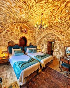 sypialnia z 2 łóżkami w kamiennej ścianie w obiekcie Fairouz Konak Otel w mieście Mardin