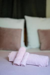 um par de toalhas cor-de-rosa sentadas numa cama em Magnificent Loft Athens Voula em Atenas