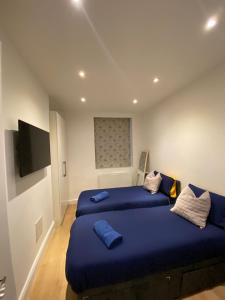 a bedroom with two beds and a flat screen tv at Elegant 2 Bed Flat in Chiswick in London