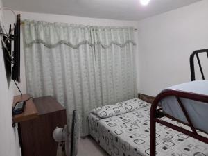 ein kleines Schlafzimmer mit einem Bett und einem Fenster in der Unterkunft J79 Apartamentos Vacacionales in Ibagué