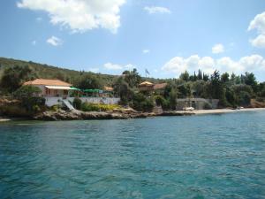 a group of houses on the shore of a body of water at Kalama Apartments in Kalamos
