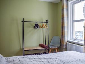 a bedroom with a bed and a chair and a window at Sea View in Anstruther