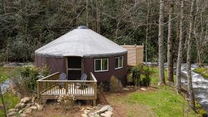 a purple yurt with a porch in the woods at stayNantahala - Smoky Mountain Cabins and Luxury Yurts in Topton