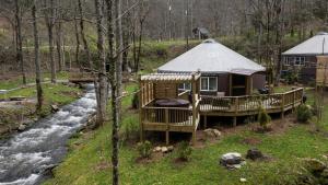 una cabaña en el bosque al lado de un río en stayNantahala - Smoky Mountain Cabins and Luxury Yurts, en Topton