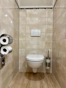 a bathroom with a toilet and two rolls of toilet paper at Hotel Stadtvilla Laux in Merzig