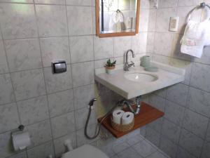 a bathroom with a sink and a toilet and a mirror at Chalés Beijupirá in Pipa