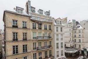 an apartment building in paris with snow on the ground at Veeve - Pompidou Hideaway in Paris