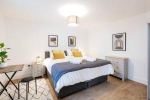 1 dormitorio con cama con almohadas amarillas y escritorio en The Upside Down Eco House, en Bristol