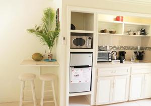 a kitchen with white cabinets and a counter with stools at Coconut Palms Hideaway in Nassau