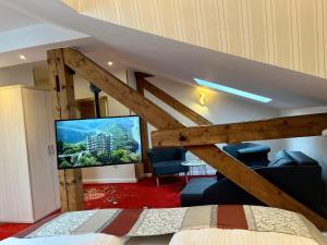 Hotel Stadtvilla Laux في مرتسيغ: غرفة نوم بسرير وتلفزيون في غرفة