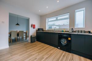a kitchen with a washing machine in the middle at Wolviston House By Horizon Stays in Stockton-on-Tees