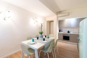 kuchnia i jadalnia z białym stołem i krzesłami w obiekcie Ricco di comfort, grande, luminoso e comodo w Wenecji