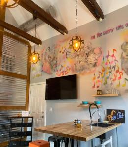 uma cozinha com uma mesa e uma televisão na parede em The Jazz Loft em Sanford